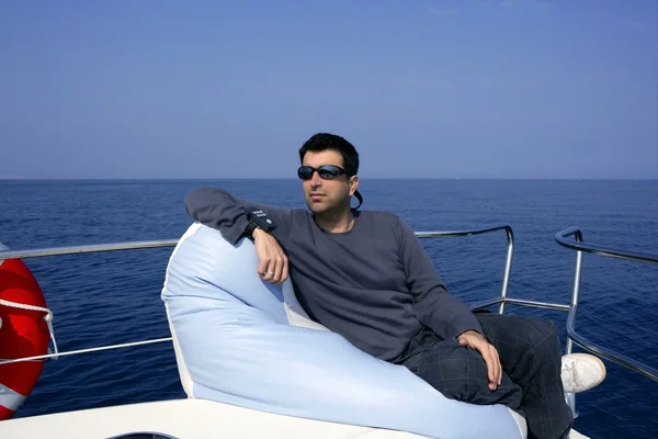 Человек на лодке расслабился на бобовом мешке — стоковое фото