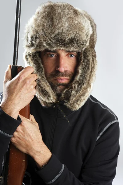 Myśliwy zimą futro kapelusz mężczyzna portret gospodarstwa pistolet — Zdjęcie stockowe