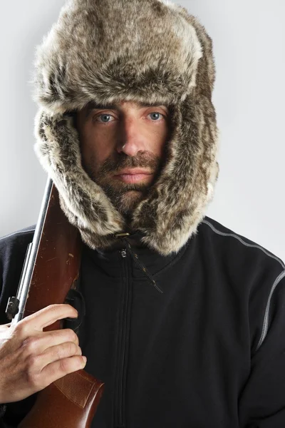 Silah tutan avcı kış kürk şapka adam portresi — Stok fotoğraf