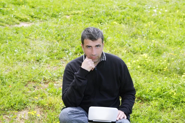 Homem trabalhando no computador caderno grama prado — Fotografia de Stock