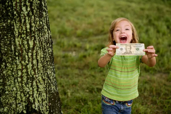 Красива щаслива маленька дівчинка з доларовою нотою — стокове фото