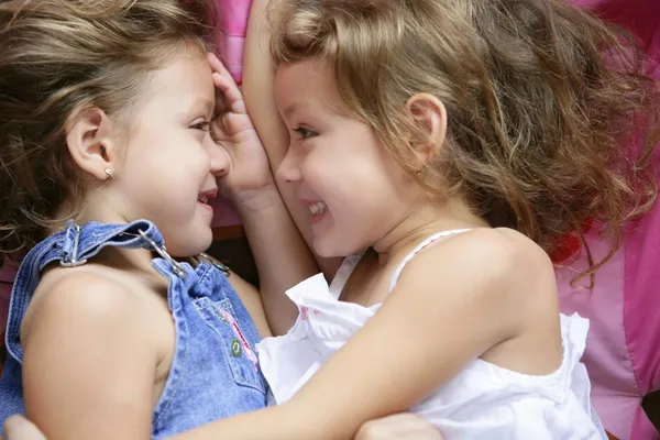 Twee tweelingzusjes in een knuffel, close-up — Stockfoto