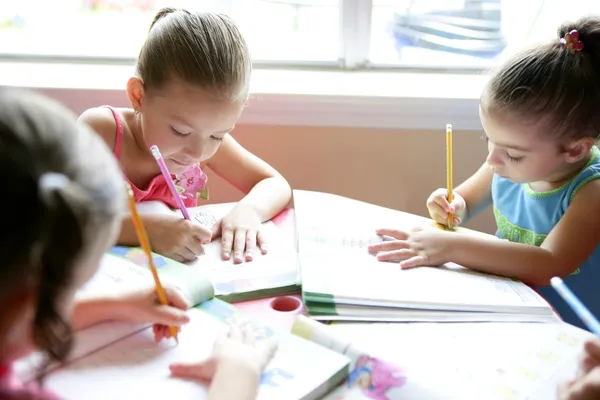 Vackra små flickor, läxor hemma — Stockfoto