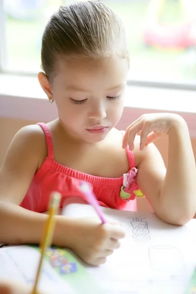 Μικρό κορίτσι μικρό παιδί γράφει στο θρανίο — Φωτογραφία Αρχείου