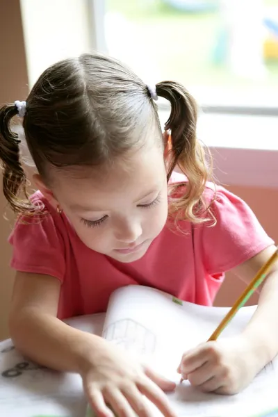 Menina criança escrevendo na mesa da escola — Fotografia de Stock