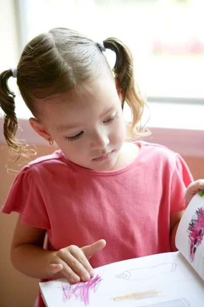 Μικρό κορίτσι μικρό παιδί γράφει στο θρανίο — Φωτογραφία Αρχείου