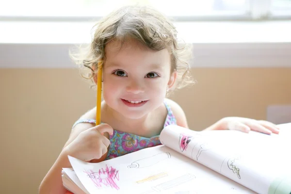 Kleines Mädchen schreibt auf der Schulbank — Stockfoto