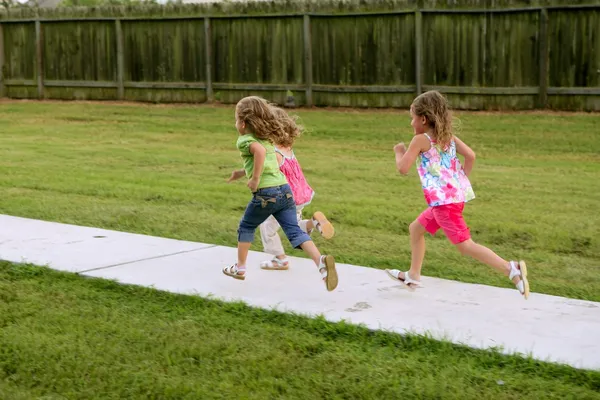 Três meninas irmãs brincando correndo no parque — Fotografia de Stock