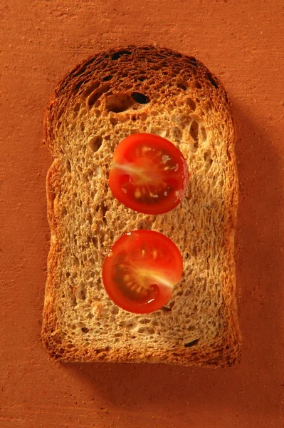 Toasted bread slices and cherry tomatoes — Stock Photo, Image
