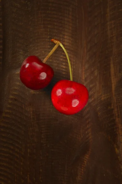 Třešňové červené ovoce přes tmavé dřevěné — Stock fotografie