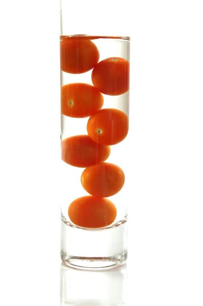 Tomates cherry en vaso de agua — Foto de Stock