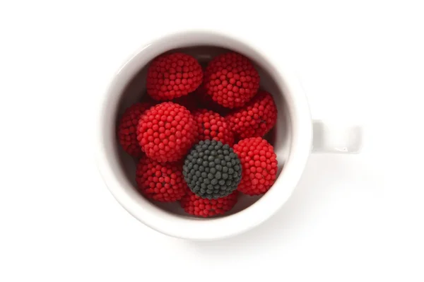 Candy berries and one different black in a coffe cup — Stock Photo, Image