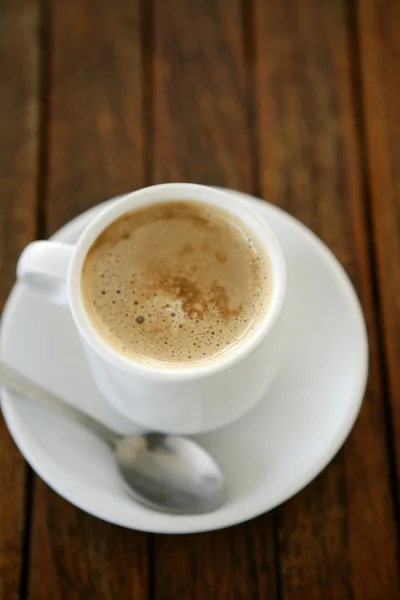 Кофе с молочно-белой чашкой на тиковом дереве — стоковое фото
