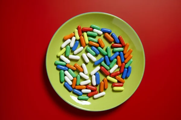 Kolorowe cukierki na żywe czerwone tło — Zdjęcie stockowe