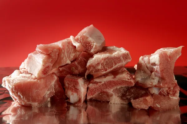 Cerdo, trozos de carne cruda de cerdo sobre rojo —  Fotos de Stock