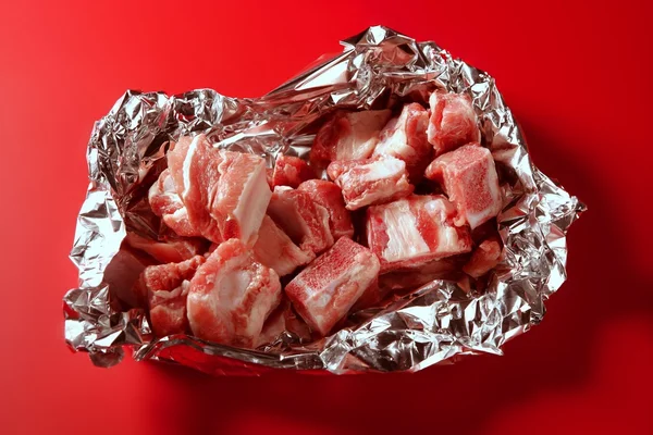 Porco, pedaços de carne crua de porco sobre vermelho — Fotografia de Stock