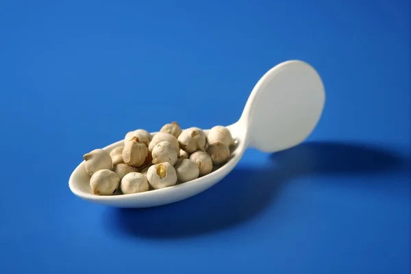 Chickpeas still spread over blue background — Stock Photo, Image