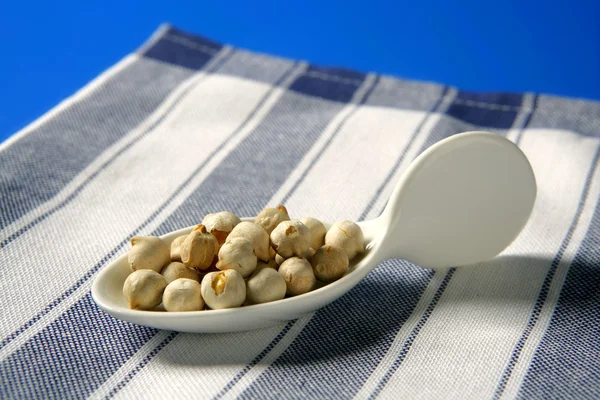 Chickpeas still spread over blue background — Stock Photo, Image