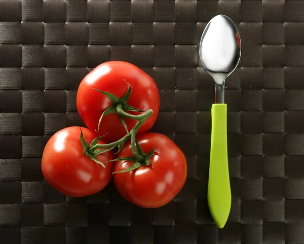 Three red tomatoes branch with green spoon — Stock Photo, Image