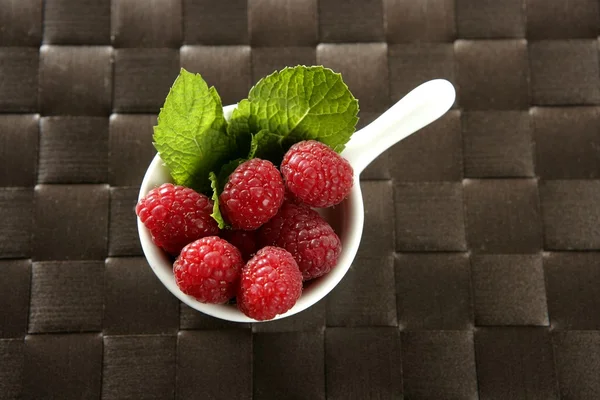 Raspberries with basil leaves — Stock Photo, Image