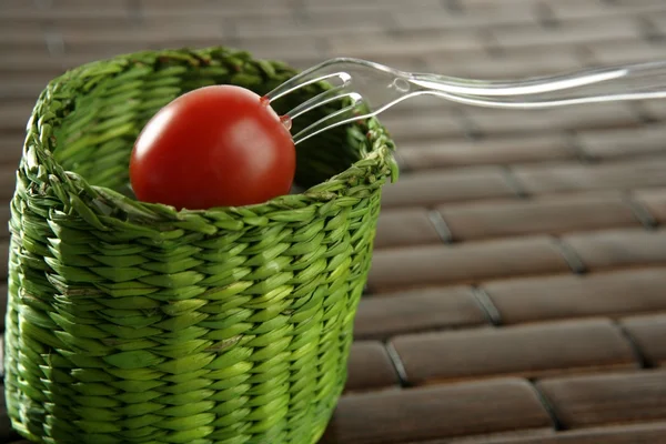 Körsbär tomat, grön korg med gaffel — Stockfoto