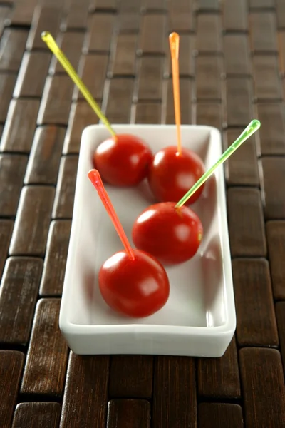 Tomatoes snack and colored sticks — Stock Photo, Image