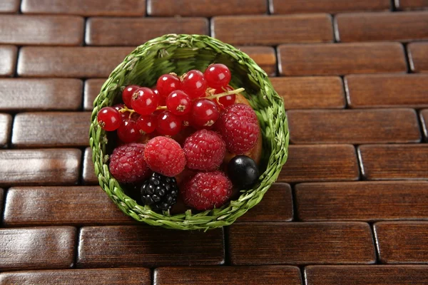 Змішані ягоди в зеленому маленькому кошику — стокове фото