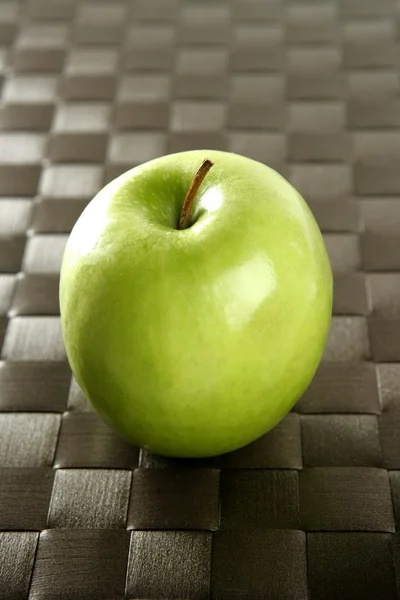 Яблоко на коричневой скатерти — стоковое фото