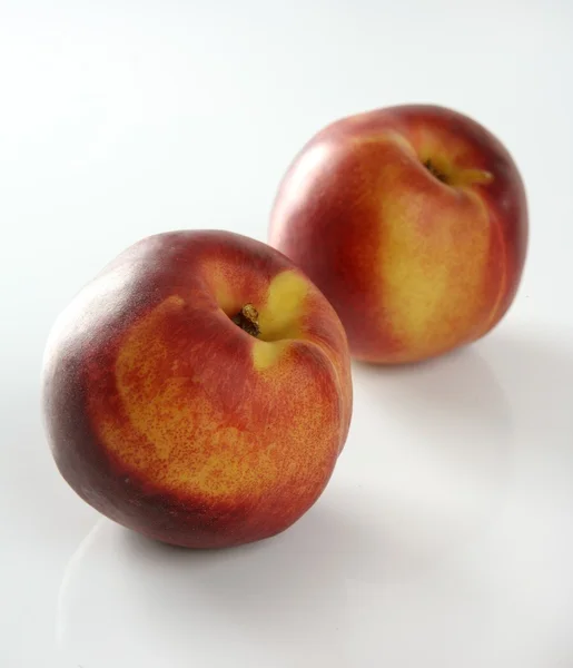 Dois pêssegos vermelhos em fundo branco — Fotografia de Stock