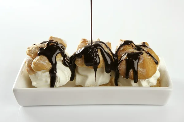 Delicious cream puff cake with chocolate syrup — Stock Photo, Image