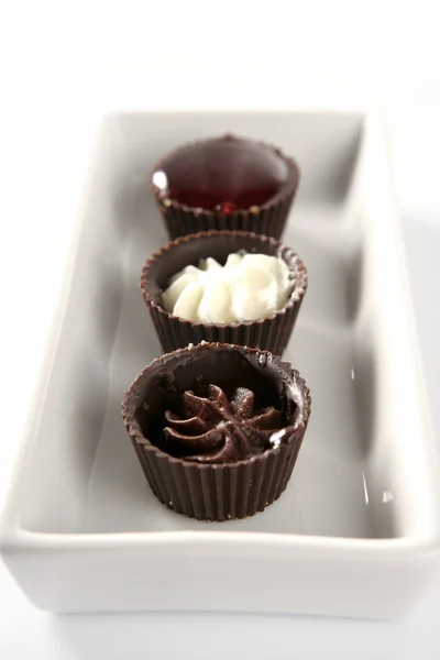 Drei kleine Schokoladenkuchen in einer Reihe — Stockfoto