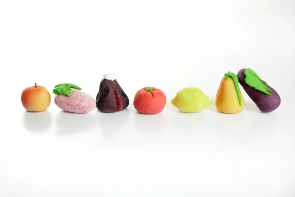 不同种类的水果上五颜六色的小杏仁饼 — 图库照片