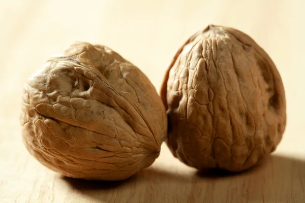 Two walnut with shells over wooden background — Stock Photo, Image