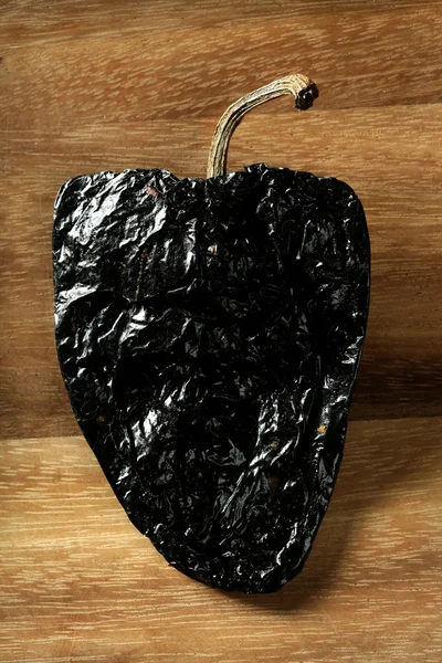 Один черный мексиканский сушеный перец чили — стоковое фото