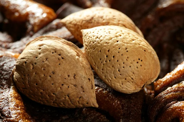 Миндальные орехи над шоколадом, вкусная золотая еда — стоковое фото