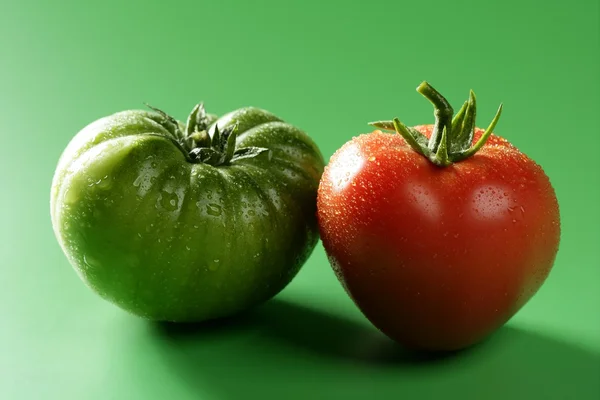 Dvě barevné rajčata, zelené a červené odrůdy — Stock fotografie