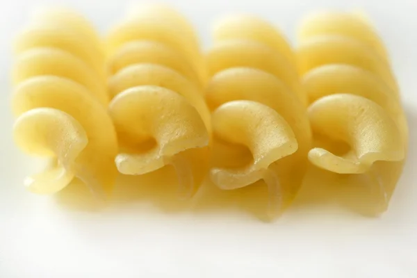 Спираль fusilli dired pasta macro поверх белого — стоковое фото