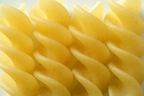 Spirale fusilli dired pasta macro over white — Stockfoto