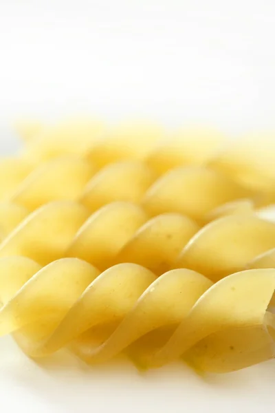 Spiral fusilli dired pasta macro over white — Stock Photo, Image
