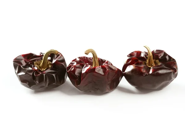 Three round Mediterranean dried dark red peppers — Stock Photo, Image