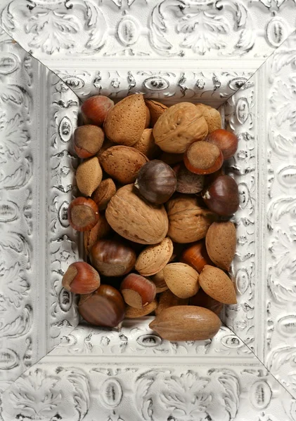 Wooden decorated classic white frame, varied nuts — Stock Photo, Image