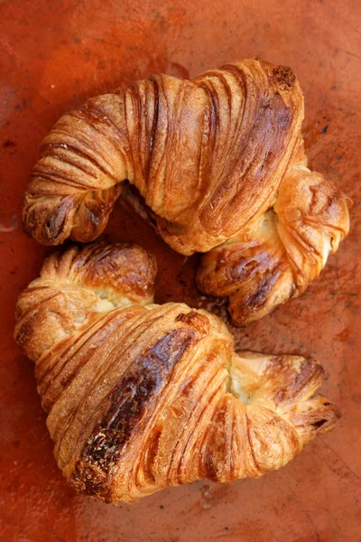 Dos pasteles de croissant sobre arcilla naranja —  Fotos de Stock