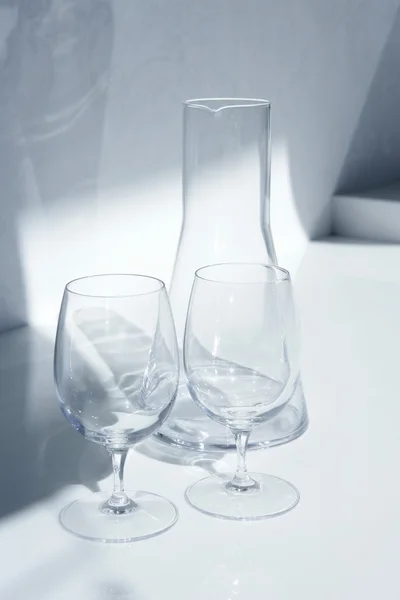 Vidrio de agua y botella con sombras transparentes —  Fotos de Stock