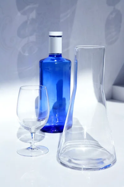 Blauwe water fles met glas, transparante schaduw — Stockfoto