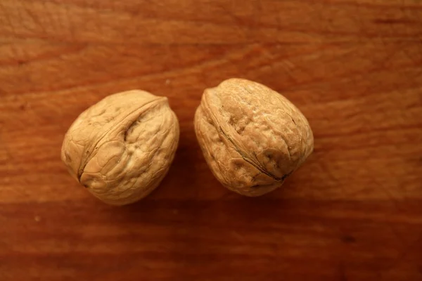 Dos nueces sobre una mesa de madera dorada —  Fotos de Stock