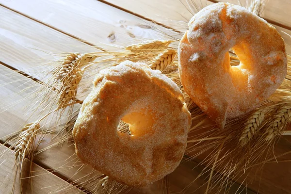 Deliciosa panadería con azúcar y espigas de trigo — Foto de Stock