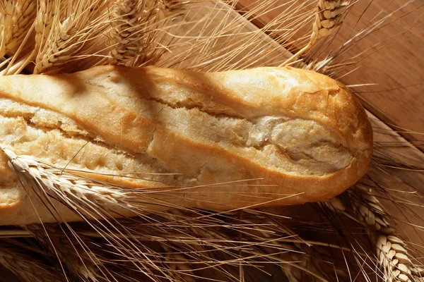 Brood over houten tafel met tarwe spikes — Stockfoto