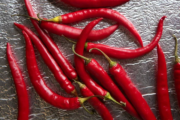 Chili hete pepers in rode patroon over zilver — Stockfoto