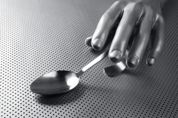 Серая серебряная рука и ложка футуристической пищи — стоковое фото