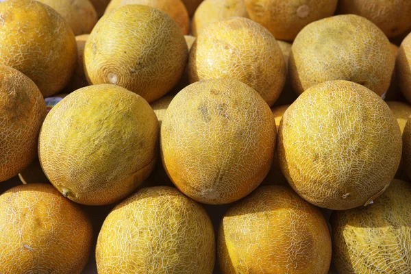 Mercado de frutos de melão amarelo fileiras empilhadas — Fotografia de Stock